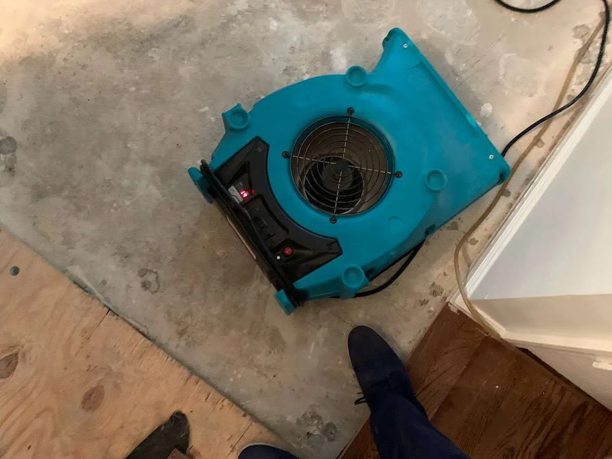 Air mover drying subfloor during Commercial Water Damage Restoration in Fishhook